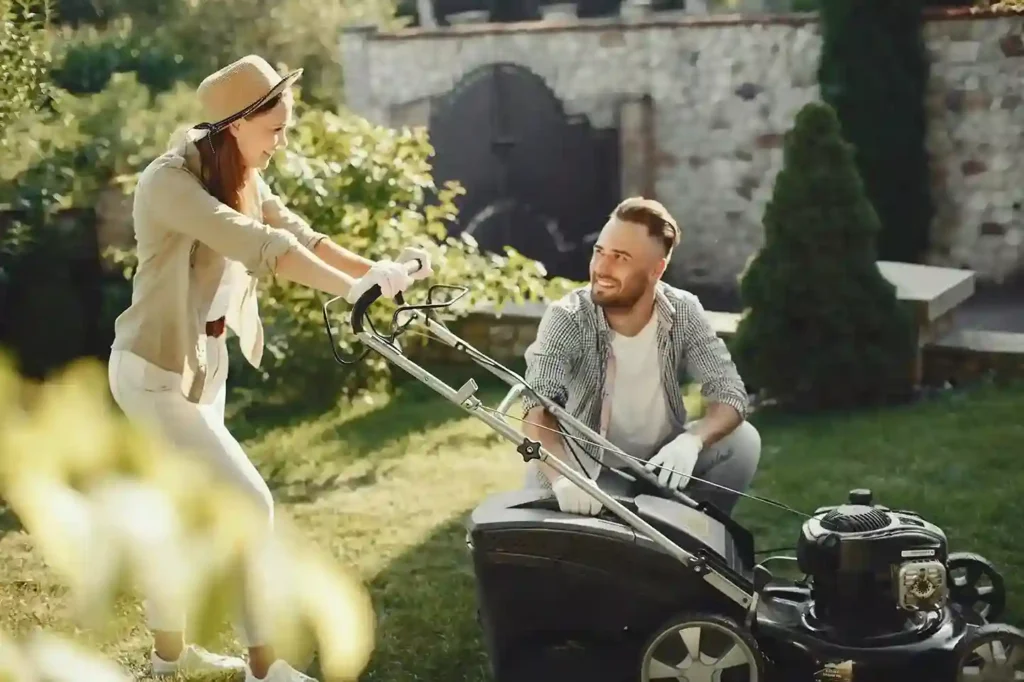 A couple working together in a garden with a lawn mower