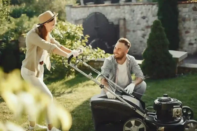 A couple working together in a garden with a lawn mower